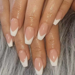 Classic French V-tip nude press on nails in medium coffin shape on gray plush background