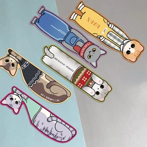 Detailed close-up of five cute cartoon cat paper bookmarks in assorted breeds on blue background