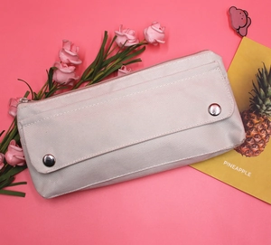 Detailed macro view of pink oxford cloth pencil case with metallic button closures