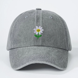 Vintage washed grey baseball cap with embroidered smiley daisy on a white background