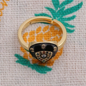 Detailed view of evil eye gold ring with black enamel heart and colorful zirconia