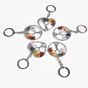 Detail view of five natural crystal tree of life keychains with colorful gemstones