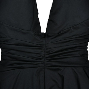 Detail of a black backless dress showing hidden zipper and elegant ruching texture