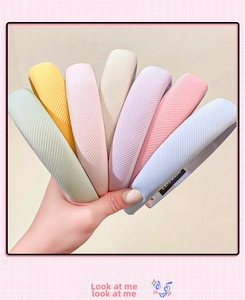 Close-up of seven assorted macaron-colored ribbed sponge headbands with handmade label