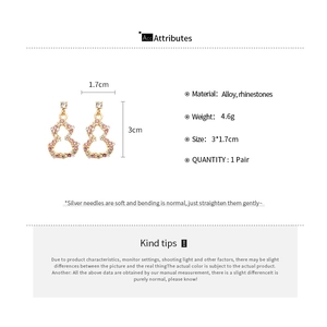 Detailed view of gold gourd drop earrings with pink rhinestones and 3x1.7cm dimensions