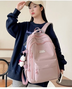 Detail of pink ergonomic backpack featuring multi-layer zipper compartments and side pockets