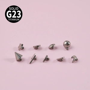 G23 titanium dermal anchor tops in various shapes like star and cone on pink background