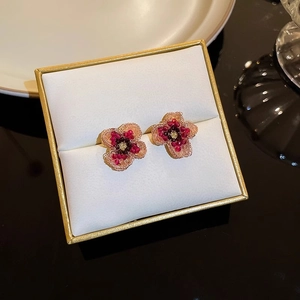 Macro detail of handmade beaded flower earrings with pink petals in a luxury jewelry box
