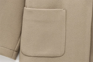 Detail of a large patch pocket on a khaki wool blend coat with neat stitching details