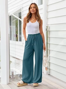 Detail of teal high-waisted wide-leg trousers with drawstring and side pocket