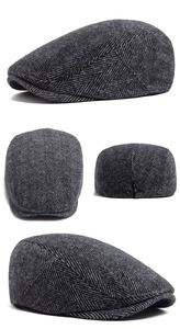 Detail view of herringbone wool newsboy cap showing metallic adjustable buckle and stitching