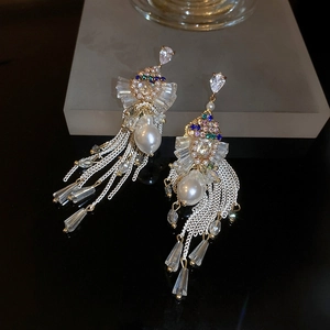 Macro shot of luxury baroque pearl tassel earrings with colorful stones and crystals