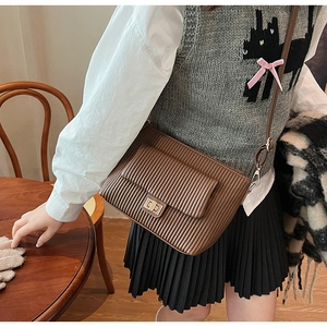 Detailed view of brown pleated leather crossbody bag with elegant gold twist lock closure