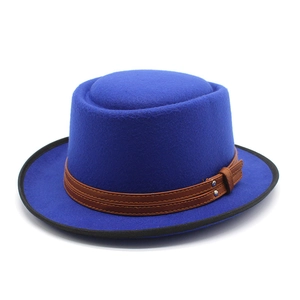 Detail of royal blue wool pork pie hat with brown leather band and metallic rivets