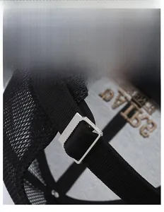 Detail of adjustable metal buckle and mesh fabric on black summer trucker baseball cap