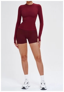 Détail de l'ensemble de yoga bordeaux avec manches longues à passe-pouce et short ajusté