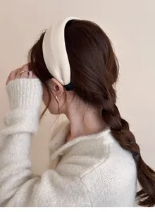 Detail view of cream thick sponge headband with soft fabric texture on model's hair