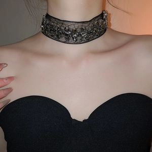 Détail d'un collier choker en dentelle noire orné de fleurs en cristal gris