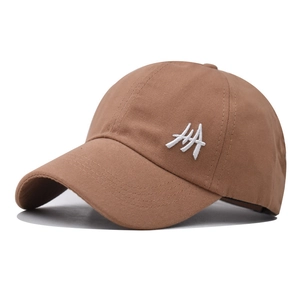 Detail of white embroidery on a brown cotton ponytail baseball cap with a smooth texture