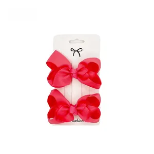 Detail of 2-piece rose red ribbed ribbon bow clips on a fashion display card