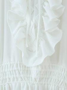 Detail of ruffled white chiffon neckline with cross lace-up ties and smocked elastic waist