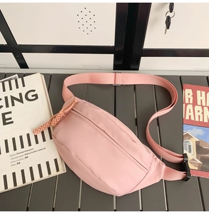 Detailed view of the pink canvas crossbody bag with adjustable strap and buckle closure