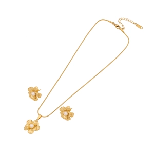 Elegant gold flower jewelry set with white pearls featuring necklace and stud earrings