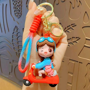Cute cartoon girl on motorcycle keychain with blue and red silicone charms and gold clasp