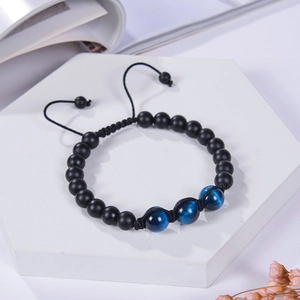 Detail of adjustable beaded bracelet with matte black beads and blue tiger eye stones