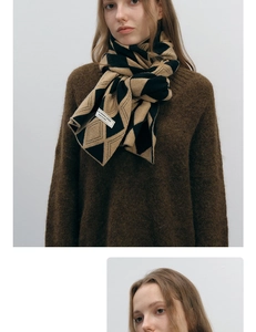 Detail of camel and black diamond pattern knit scarf draped on a model's neck