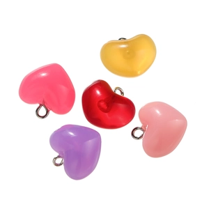 Macro shot of colorful acrylic heart pendants in various pastel shades with metal hooks