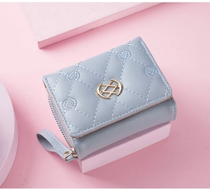 Detail of light blue quilted leather wallet with gold logo and smooth zipper closure