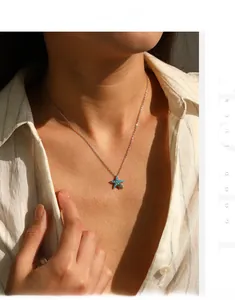 Detail of a vintage S925 silver starfish necklace with turquoise on a female model
