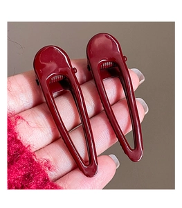 Detail of burgundy geometric spray-painted metal hair clips with hollow-out design