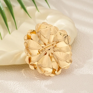 Macro detail of the golden flower brooch back pin structure and metallic finish