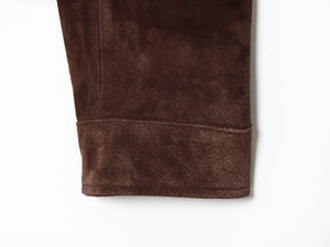 Macro view of brown faux suede sleeve cuffs with precision double-stitch sewing details
