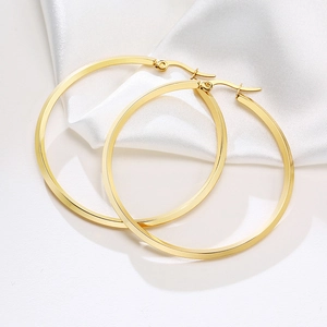 Fashionable gold plated oversized hoop earrings for women on white silk background