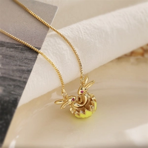 Collana dorata con pendente a forma di coniglio e guscio d'uovo giallo con zirconi rossi