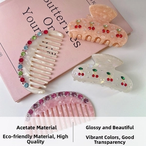 Detail of acetate hair comb with gradient rhinestones and cherry motif hair claw clips