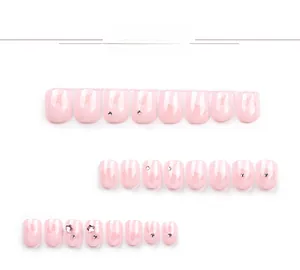 Gros plan sur ongles roses avec motifs de cœurs, strass et paillettes d'étoiles