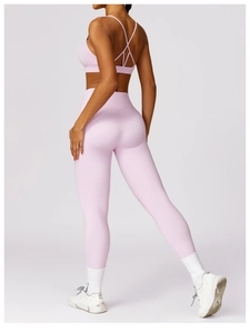 Detailed back view of pink high-waisted yoga leggings and cross-back sports bra set