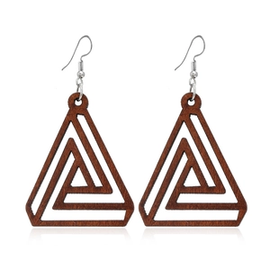 Gros plan de boucles d'oreilles en bois marron géométriques avec des crochets argentés