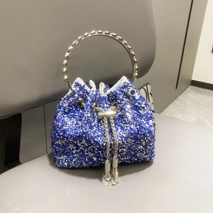 Detail of blue bucket bag with rhinestones, metal ring handle, and tassel chain