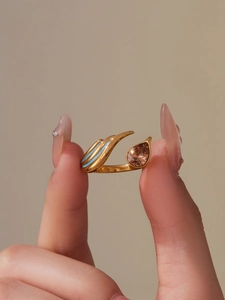 Detailed close-up of adjustable gold ring with teardrop zircon and blue enamel lines