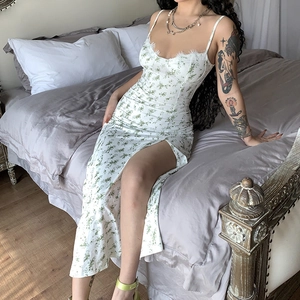 Detail of floral sundress with lace trim neckline and side slit on white and green fabric