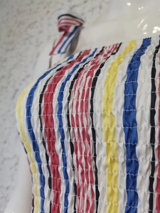 Detailed close-up of vertical striped elastic smocked fabric for summer dress