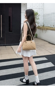 Sac bowling matelassé beige chic avec logo doré présenté dans un style urbain élégant