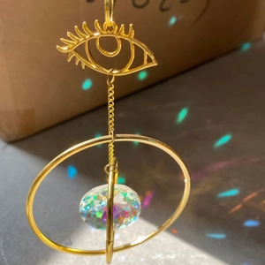 Golden suncatcher with eye design metal plate and faceted crystal ball for rainbow prism