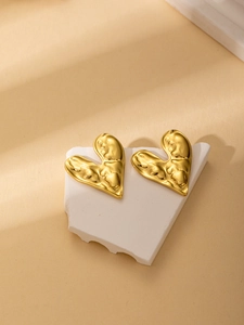 Detailed view of 18K gold plated heart earrings with irregular hammered texture