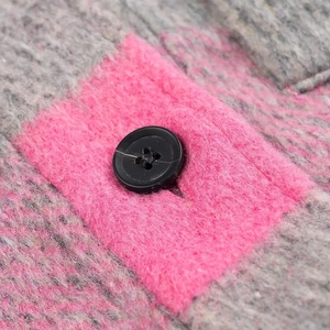Macro shot of pink and gray checkered mohair fabric with a black button detail